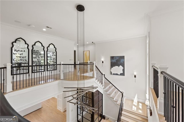 hall with light wood-type flooring and crown molding