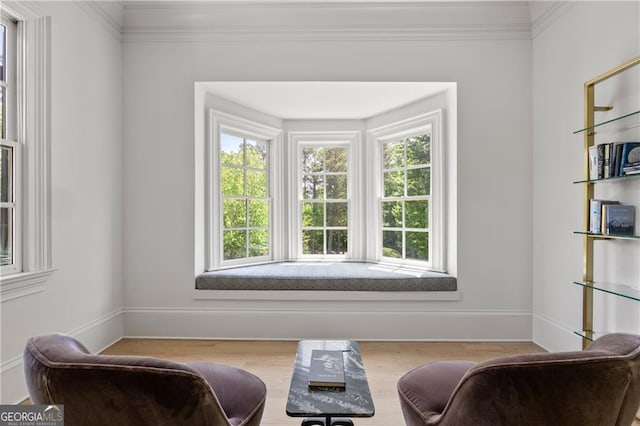 living area featuring hardwood / wood-style flooring, plenty of natural light, and ornamental molding