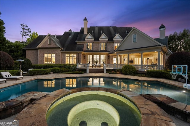 exterior space with a patio and an in ground hot tub