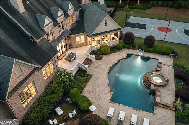 view of swimming pool featuring an in ground hot tub and a patio