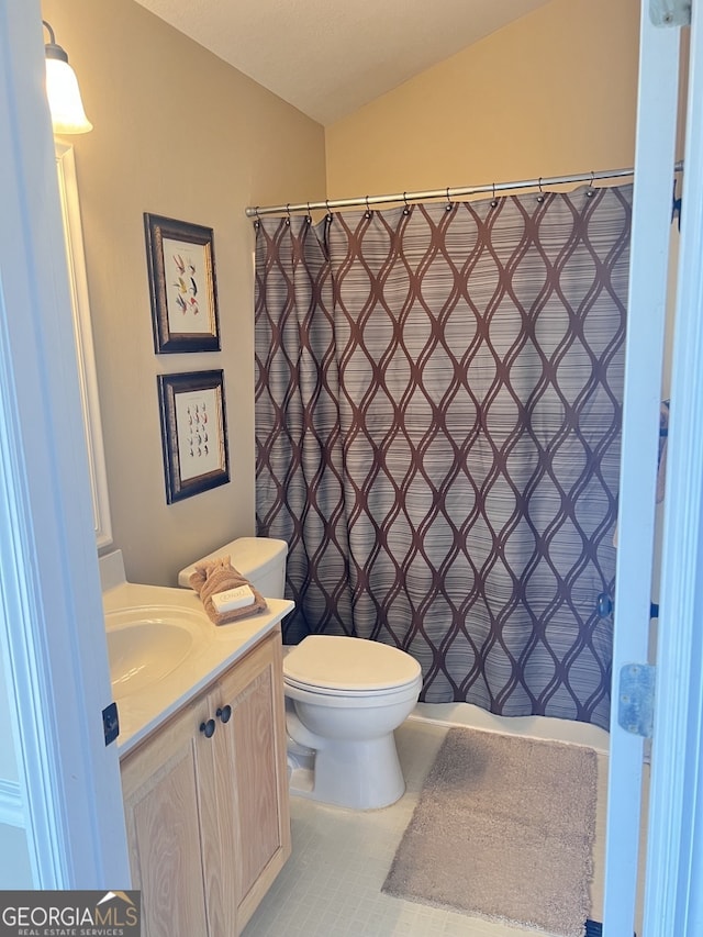 bathroom with vanity, toilet, and vaulted ceiling