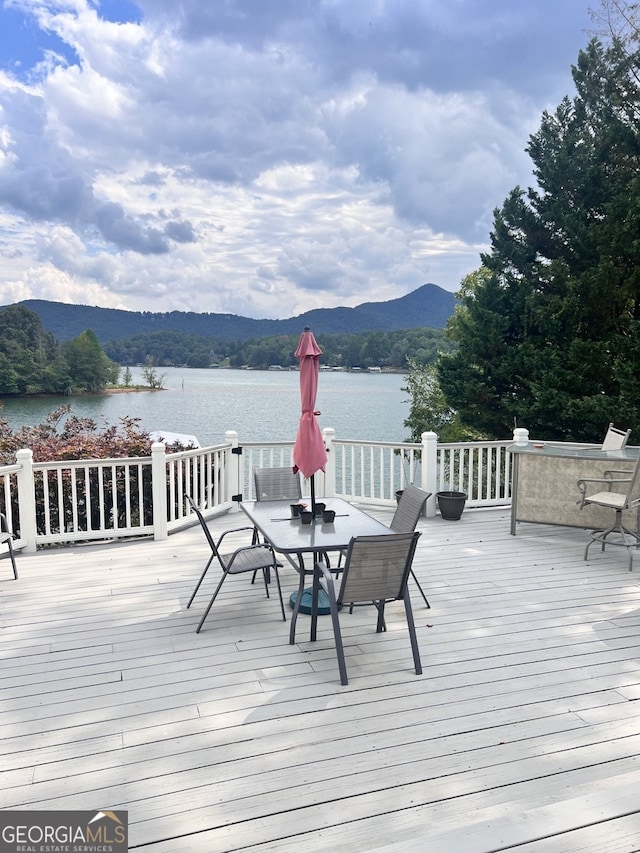 wooden deck with a water and mountain view