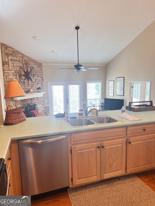 kitchen with lofted ceiling, dishwasher, sink, and a fireplace