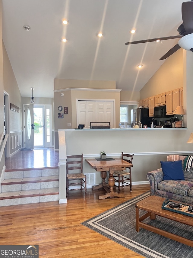 living room featuring high vaulted ceiling, ceiling fan, and wood-type flooring