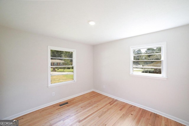 empty room featuring light wood-type flooring and a healthy amount of sunlight