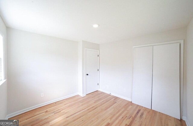 unfurnished bedroom featuring a closet and hardwood / wood-style flooring