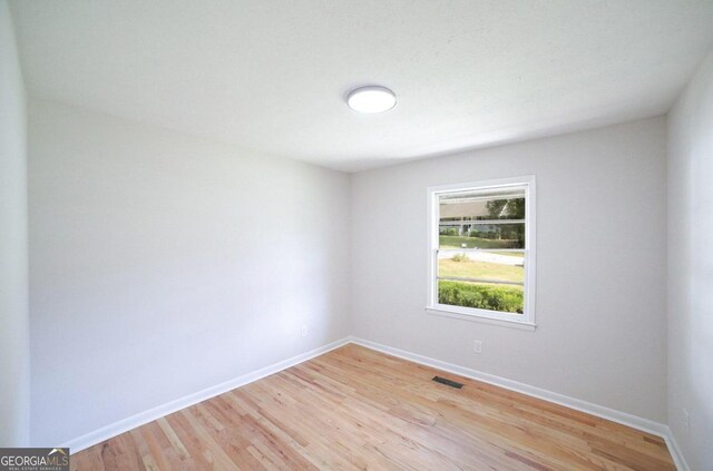 unfurnished room with wood-type flooring