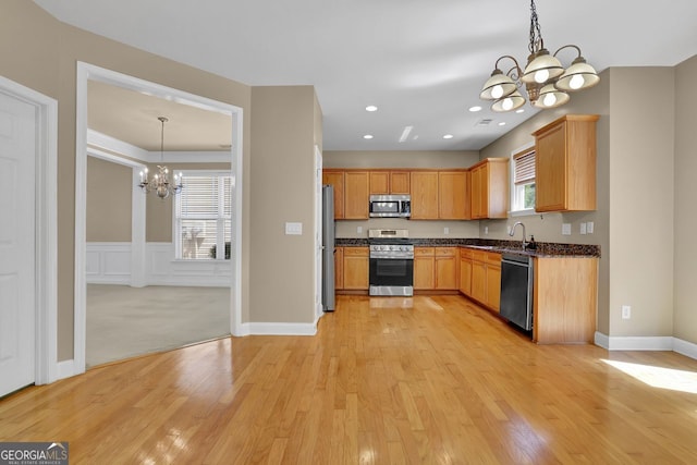 kitchen with pendant lighting, stainless steel appliances, light hardwood / wood-style floors, and a notable chandelier