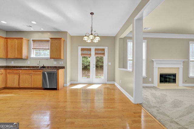 kitchen with pendant lighting, sink, stainless steel dishwasher, light hardwood / wood-style floors, and french doors