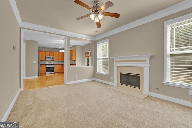 unfurnished living room with crown molding, light carpet, a wealth of natural light, and a fireplace