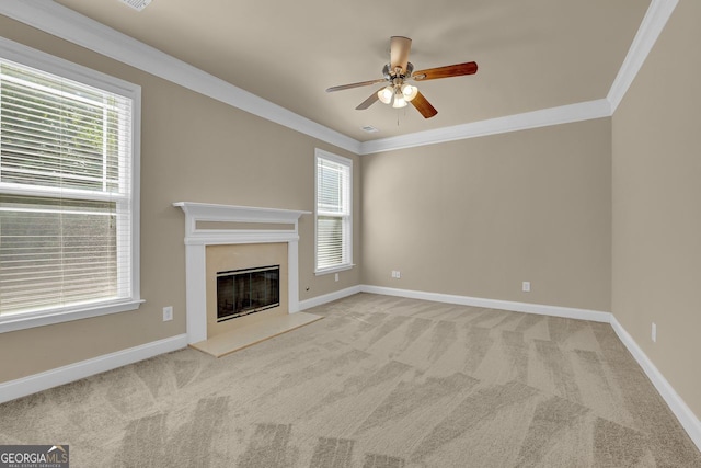 unfurnished living room featuring crown molding, light colored carpet, ceiling fan, and a wealth of natural light