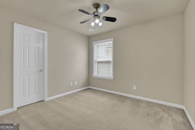 carpeted spare room featuring ceiling fan