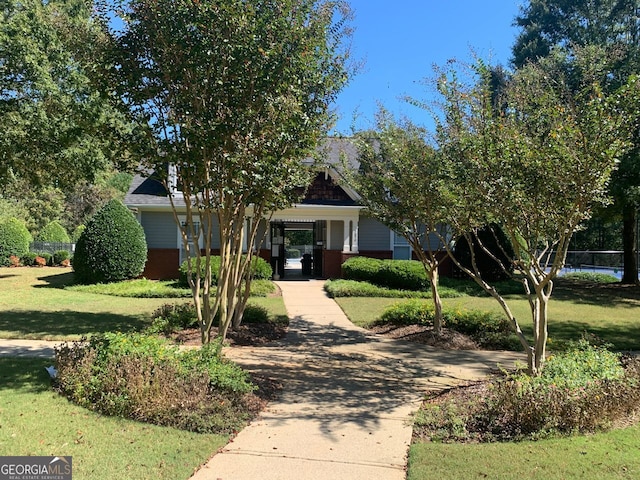 obstructed view of property with a front lawn