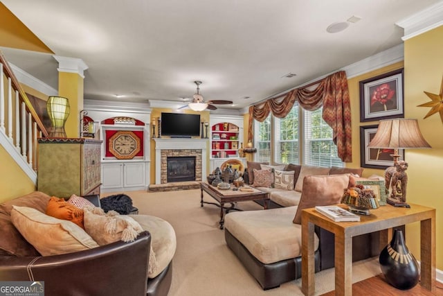 living room featuring crown molding, ceiling fan, and a fireplace