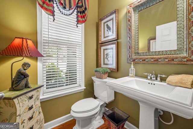 bathroom with toilet, sink, and hardwood / wood-style flooring