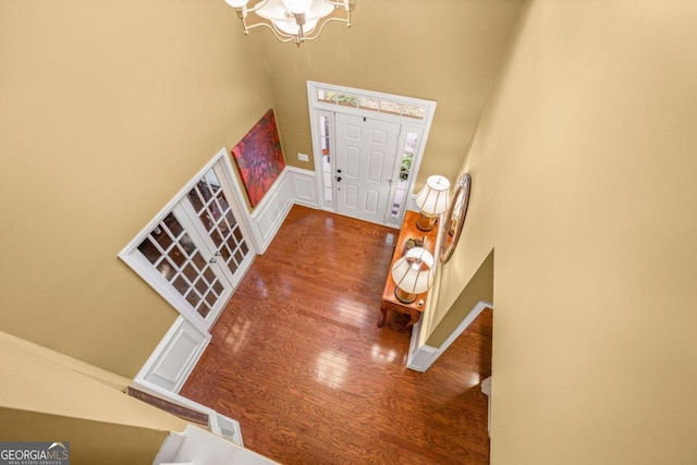 entryway featuring a high ceiling, hardwood / wood-style floors, and an inviting chandelier