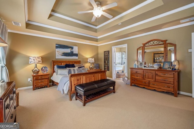 carpeted bedroom with crown molding, ceiling fan, ensuite bathroom, and a tray ceiling