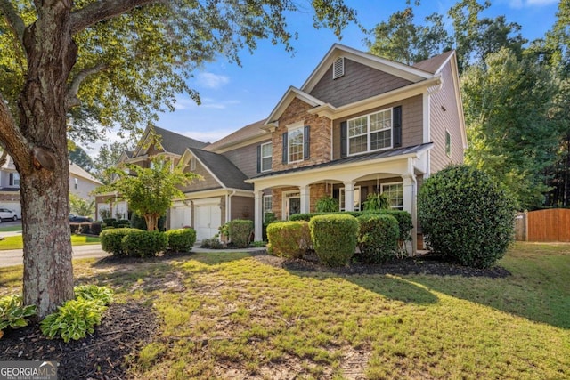 view of front of house with a garage, a front yard, and covered porch