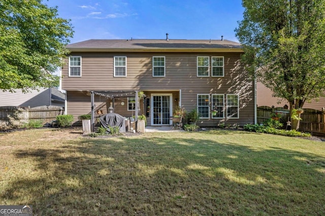 rear view of house with a yard and a patio