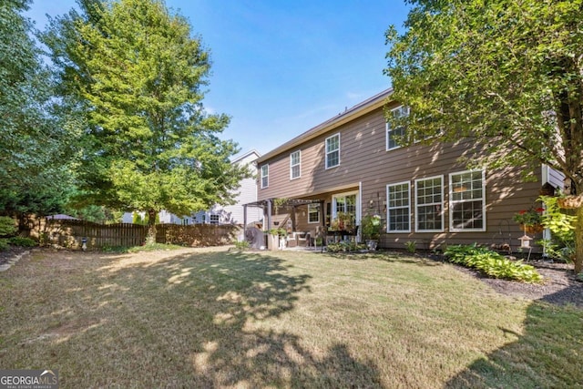 rear view of property with a lawn and a patio area