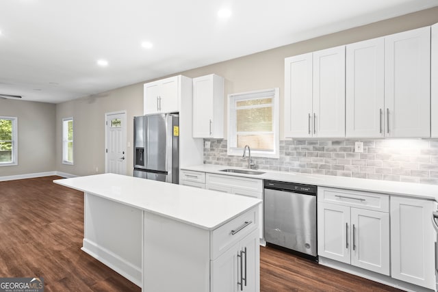 kitchen with appliances with stainless steel finishes, sink, white cabinets, and dark wood-type flooring