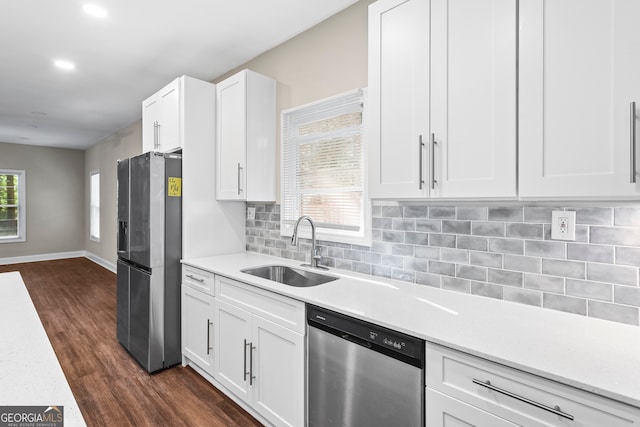 kitchen featuring dark hardwood / wood-style floors, backsplash, appliances with stainless steel finishes, sink, and white cabinetry