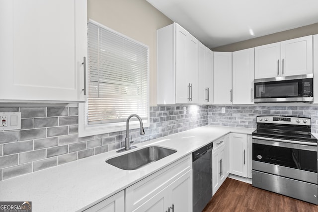 kitchen featuring appliances with stainless steel finishes, sink, white cabinets, and dark wood-type flooring