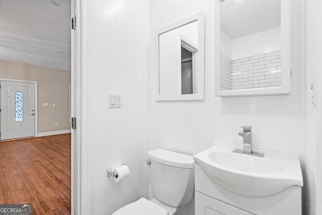 bathroom with vanity, toilet, and hardwood / wood-style flooring