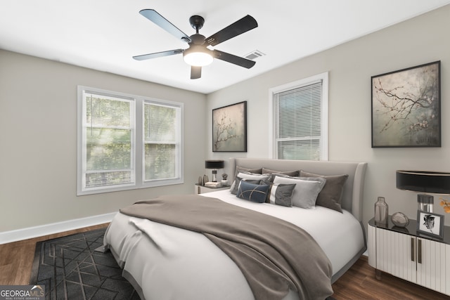 bedroom with dark hardwood / wood-style flooring and ceiling fan