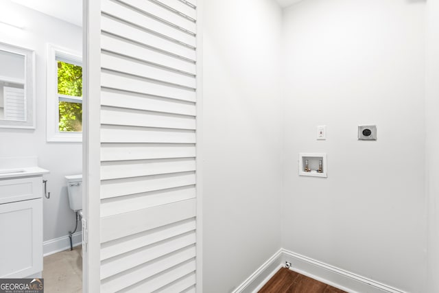 laundry area with washer hookup, wood-type flooring, hookup for an electric dryer, and cabinets