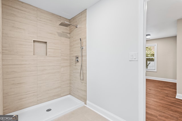 bathroom featuring hardwood / wood-style flooring and tiled shower