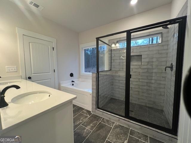 bathroom with vanity and independent shower and bath