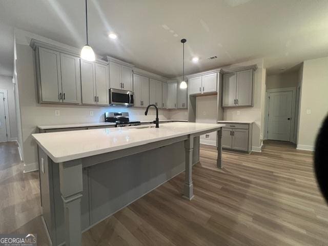 kitchen featuring gray cabinetry, pendant lighting, and appliances with stainless steel finishes