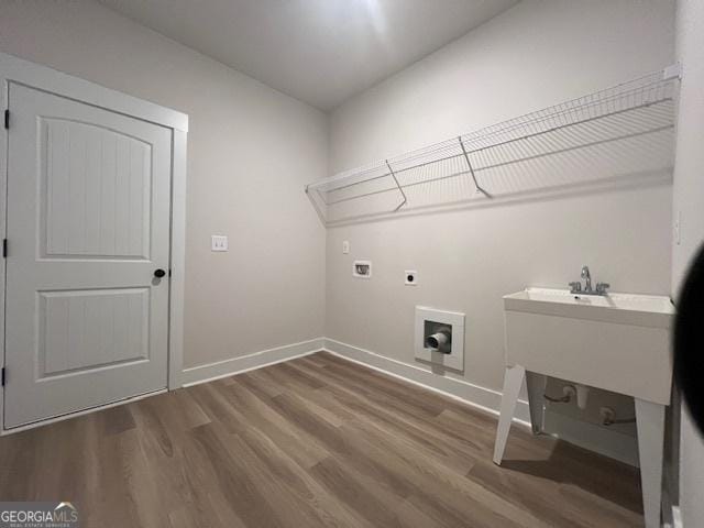 washroom with sink, hookup for a washing machine, wood-type flooring, and hookup for an electric dryer