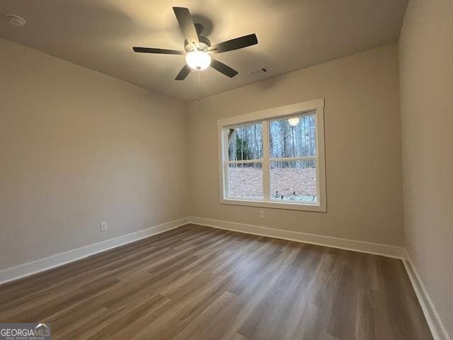 empty room featuring ceiling fan and dark wood-type flooring