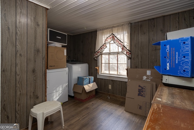 laundry room with washer and dryer, wood walls, and wood-type flooring