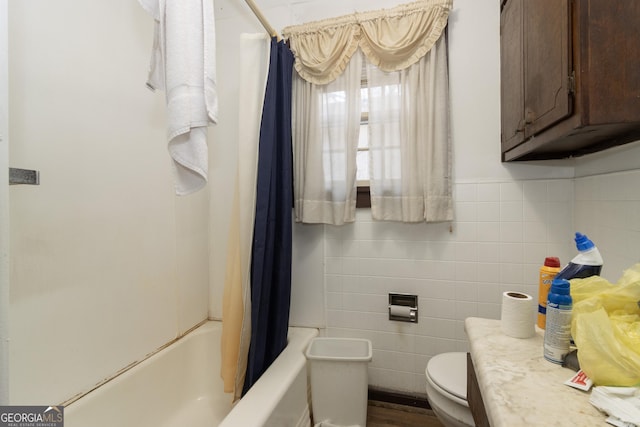 full bathroom featuring shower / bath combo, vanity, toilet, and tile walls