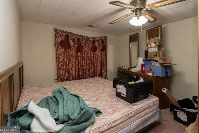 carpeted bedroom with ceiling fan and ornamental molding