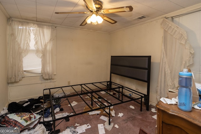 carpeted bedroom with ceiling fan and ornamental molding