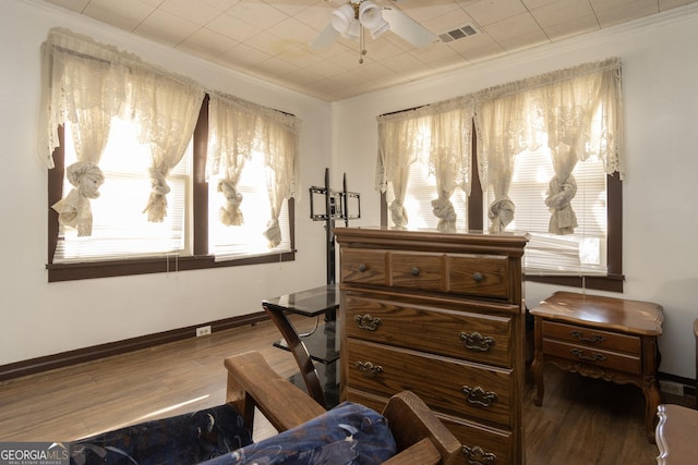 sitting room with ceiling fan, crown molding, and hardwood / wood-style flooring