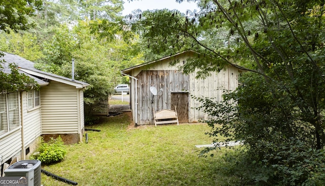 view of outbuilding with a yard and central air condition unit