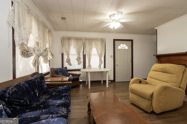 living room with crown molding, ceiling fan, and dark wood-type flooring