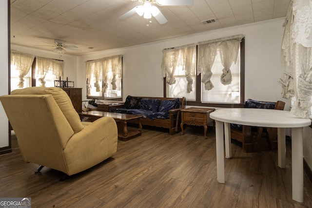 living room with dark hardwood / wood-style floors, ceiling fan, and crown molding