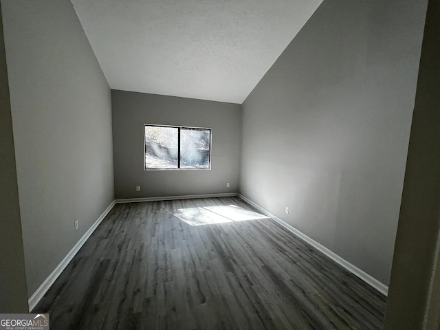 unfurnished room featuring baseboards, a textured ceiling, lofted ceiling, and dark wood-style floors