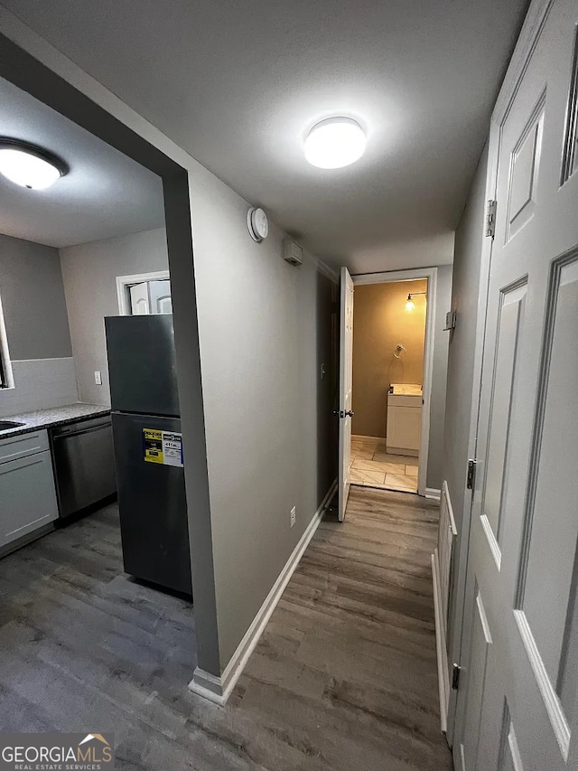 hallway featuring dark wood-style floors and baseboards