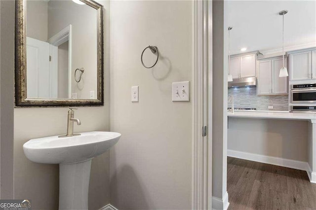 bathroom featuring backsplash and hardwood / wood-style flooring