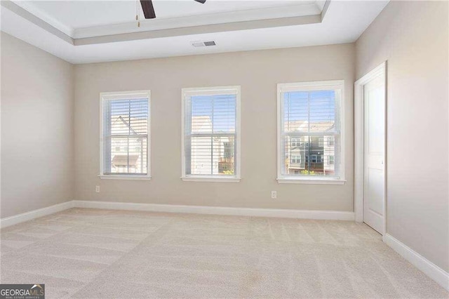 carpeted empty room featuring ceiling fan and a tray ceiling