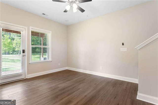 empty room featuring dark wood-type flooring and ceiling fan