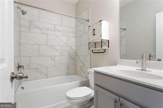 full bathroom with tiled shower / bath, vanity, and toilet