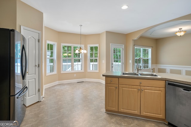 kitchen with pendant lighting, stainless steel appliances, sink, and an inviting chandelier